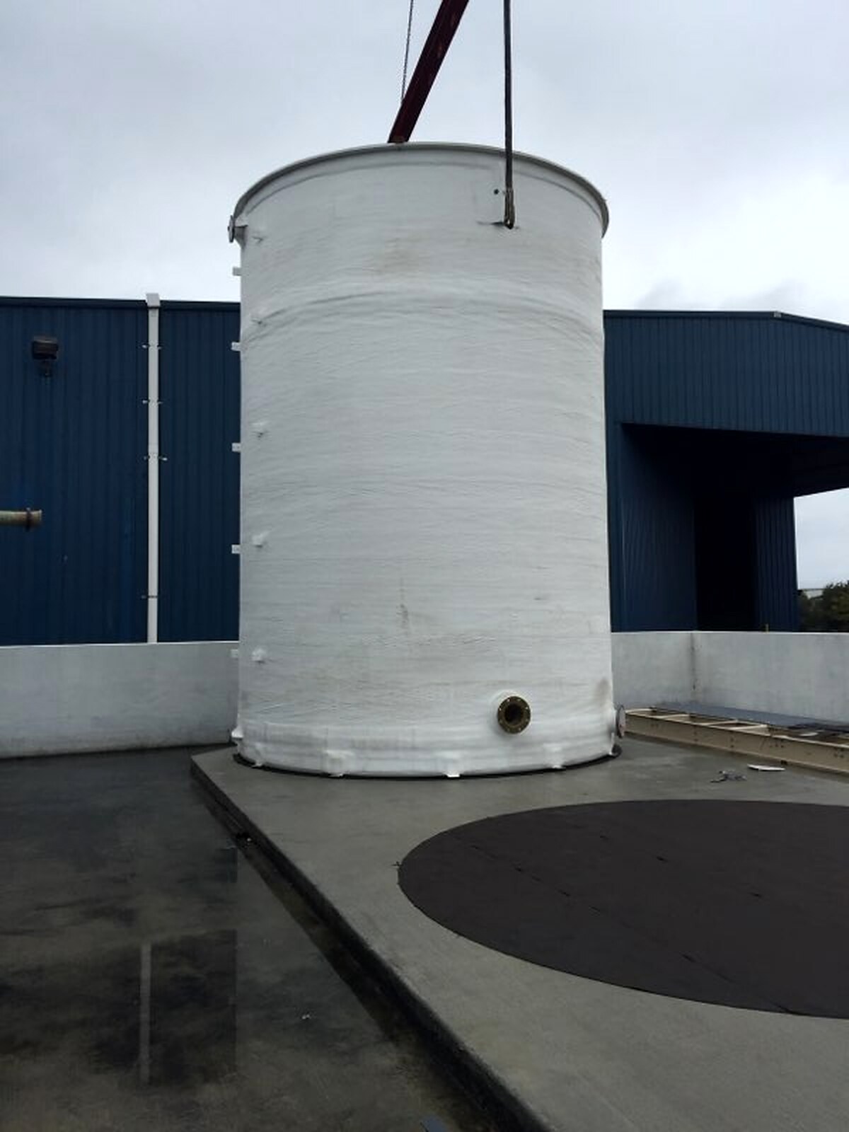 Fiberglass storage tank being set on its foundation
